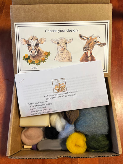 Open Wooly Washer felted soap kit box showing design selection card with illustrated cow, lamb, and goat options, printed wet-felting instructions, a bar of soap, felting needle, pantyhose, and assorted wool roving in natural colors.
