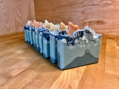 Row of colorful soap bars on a wooden surface