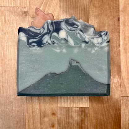 Marbled gray, blue and white soap bar on a wooden surface